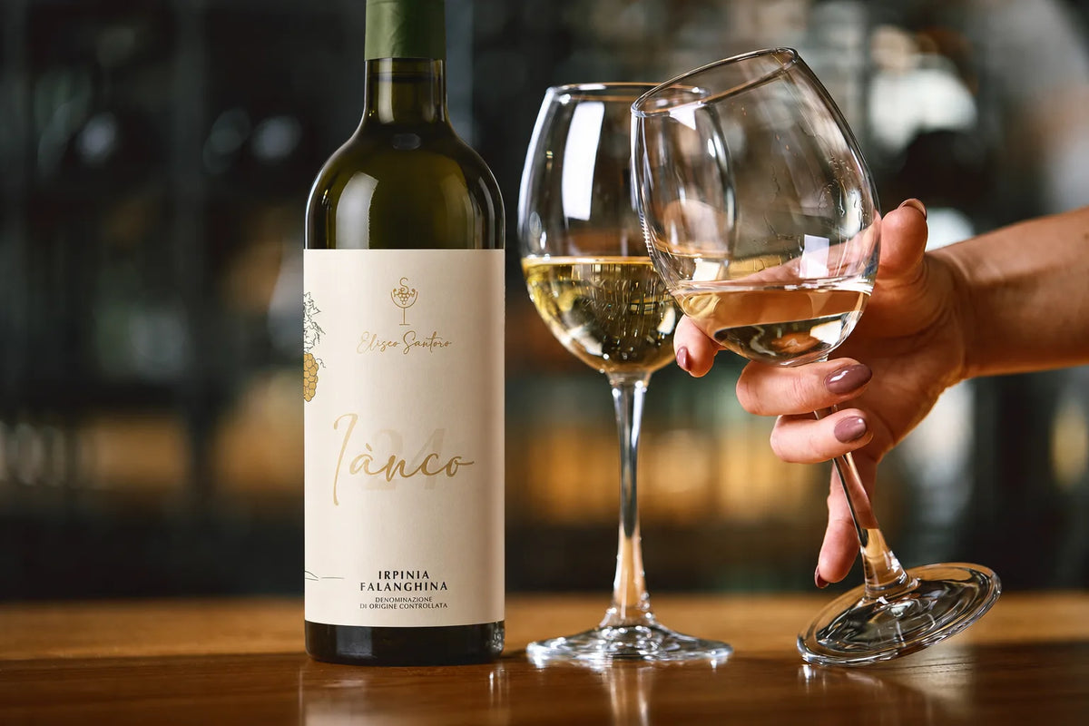 Bottiglia di Iànco Irpinia Falanghina DOC di Eliseo Santoro con calici di vino bianco
