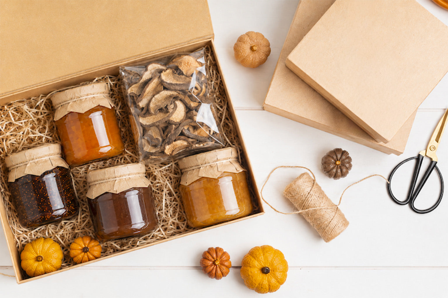 Box gastronomica con conserve, confetture e prodotti secchi, preparata con materiali per confezionamento artigianale.