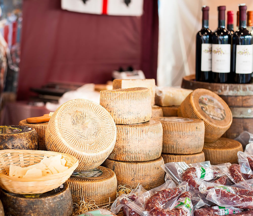 Selezione di formaggi stagionati, salumi artigianali e vini, rappresentativa della tradizione gastronomica locale.