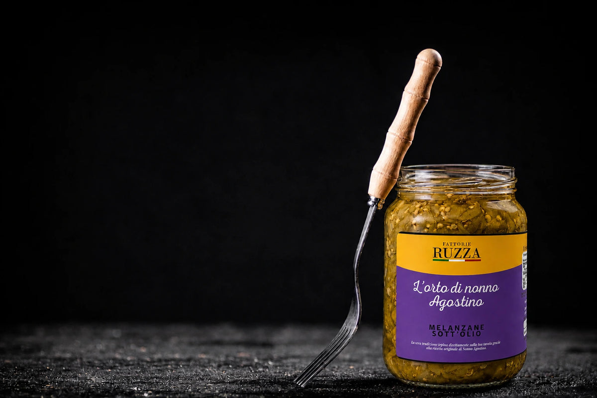 Vasetto aperto di melanzane sott’olio Fattorie Ruzza con forchetta, su fondo nero.