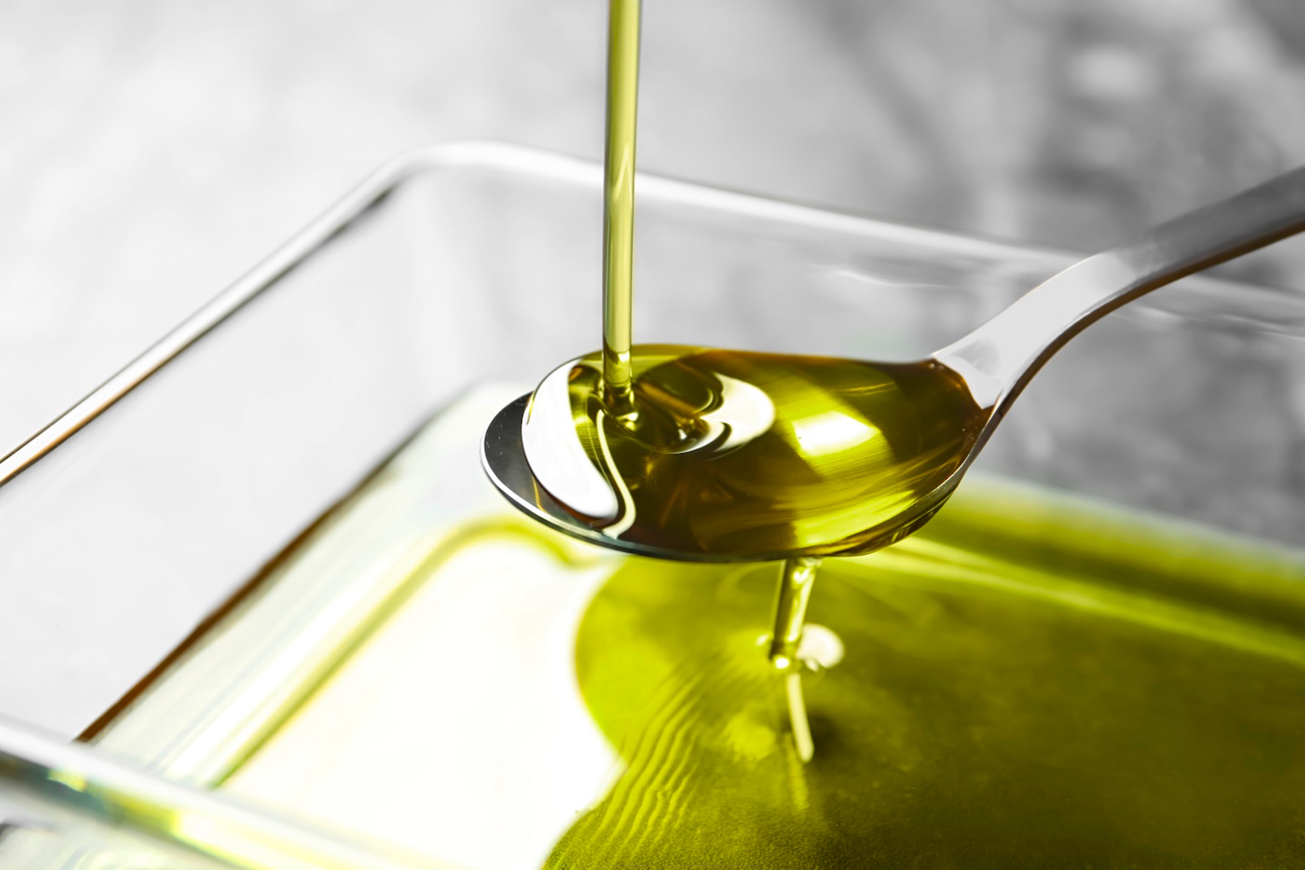 Olio extravergine di oliva irpino versato su un cucchiaio, con colore verde intenso e consistenza fluida