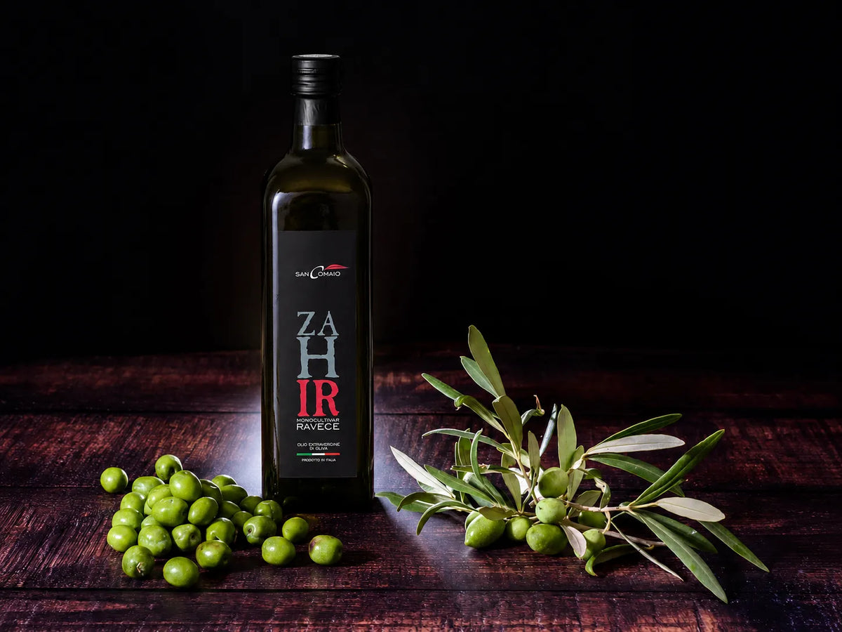 `Bottiglia di olio extravergine di oliva Zahir Monocultivar Ravece di San Comaio con olive e ramo di ulivo`