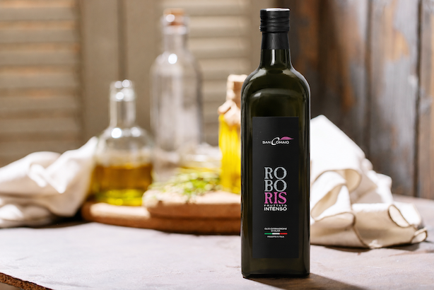 Olio extravergine di oliva Roboris Fruttato Intenso di San Comaio, bottiglia ambientata su una tavola